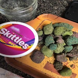 Skittles MoonRock cannabis flower infused with hash oil and rolled in kief, offering a sweet, fruity flavor and strong effects.